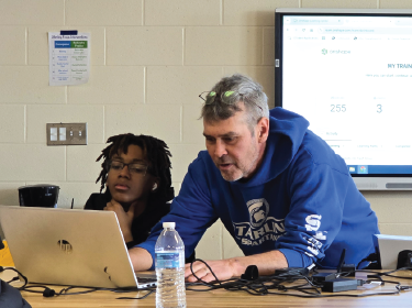 student and teacher looking puzzled at computer screen